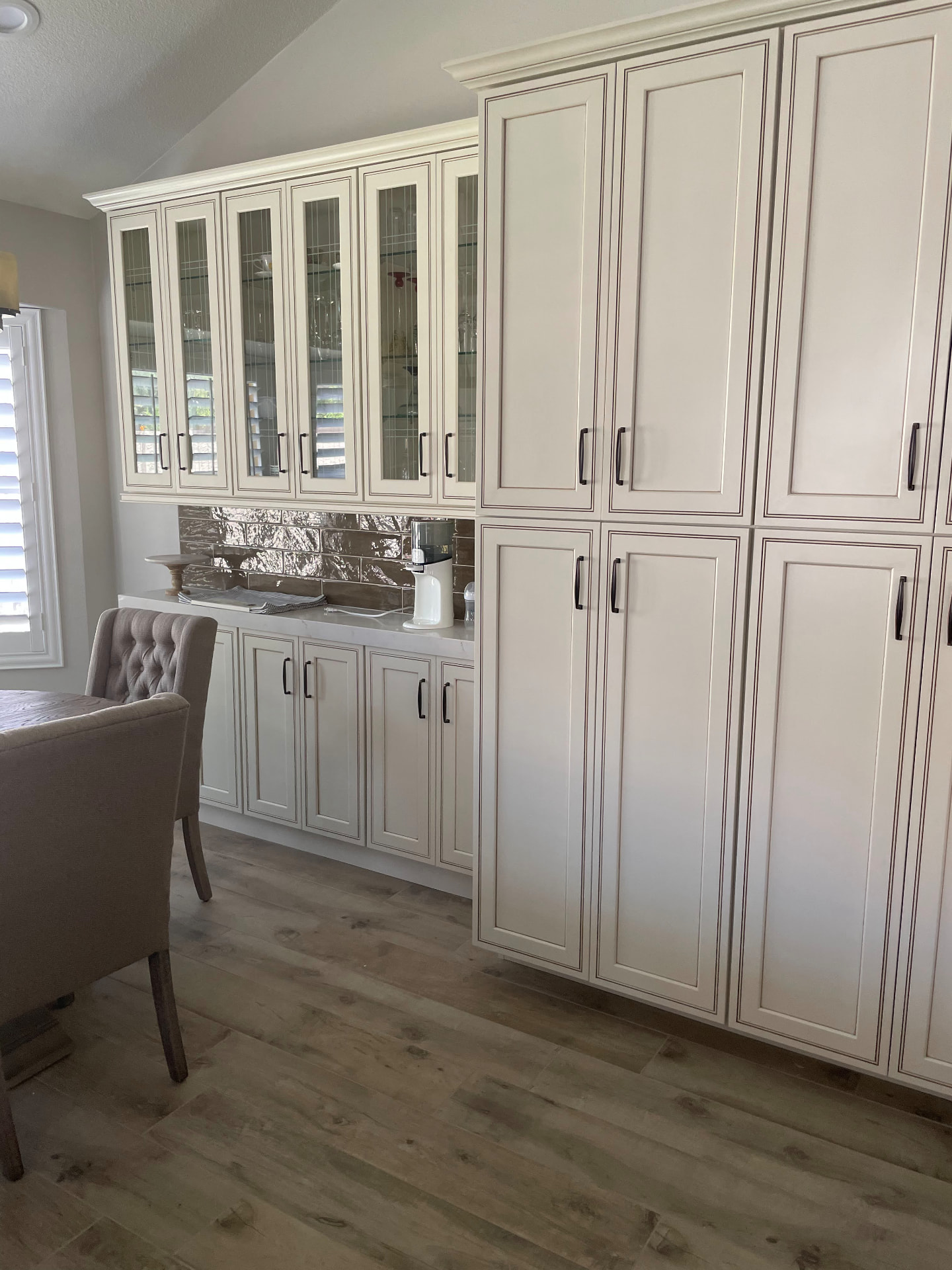 Floor to ceiling pantry cabinetry with glass front hutch
