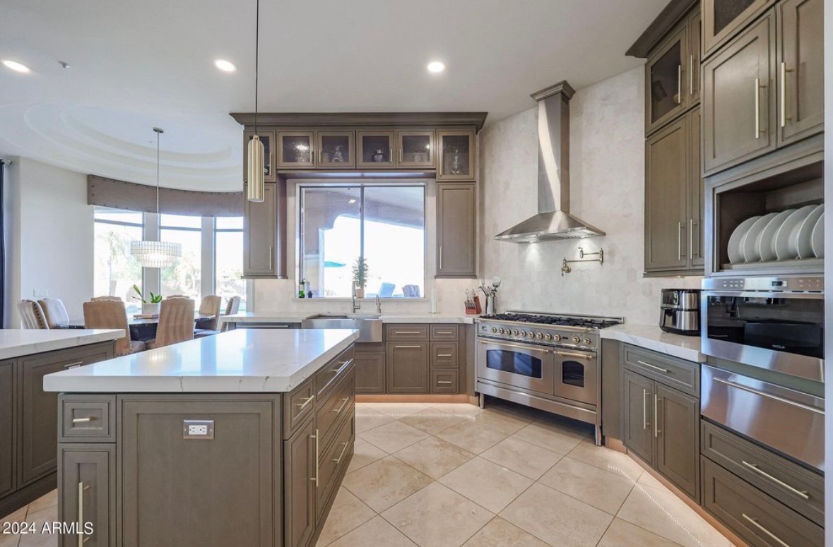 Quartz waterfall island with greige perimeter cabinetry